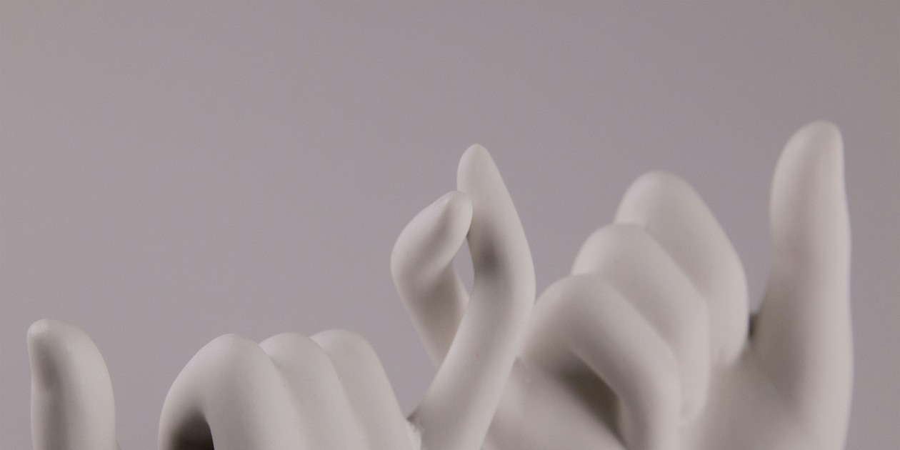 Two sculpture hands with pinkies about to interlock