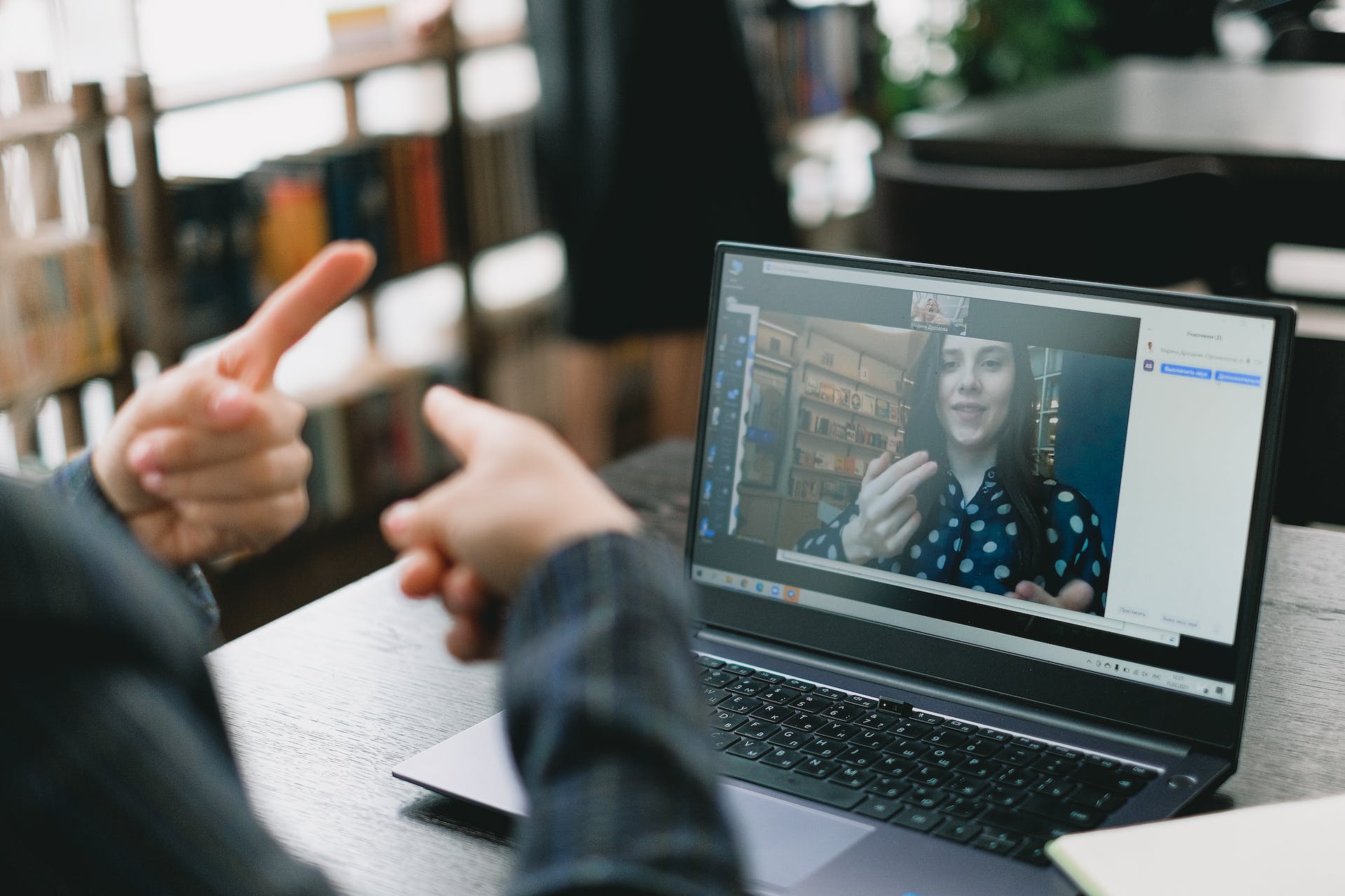 A laptop screen showing a woman doing sign language