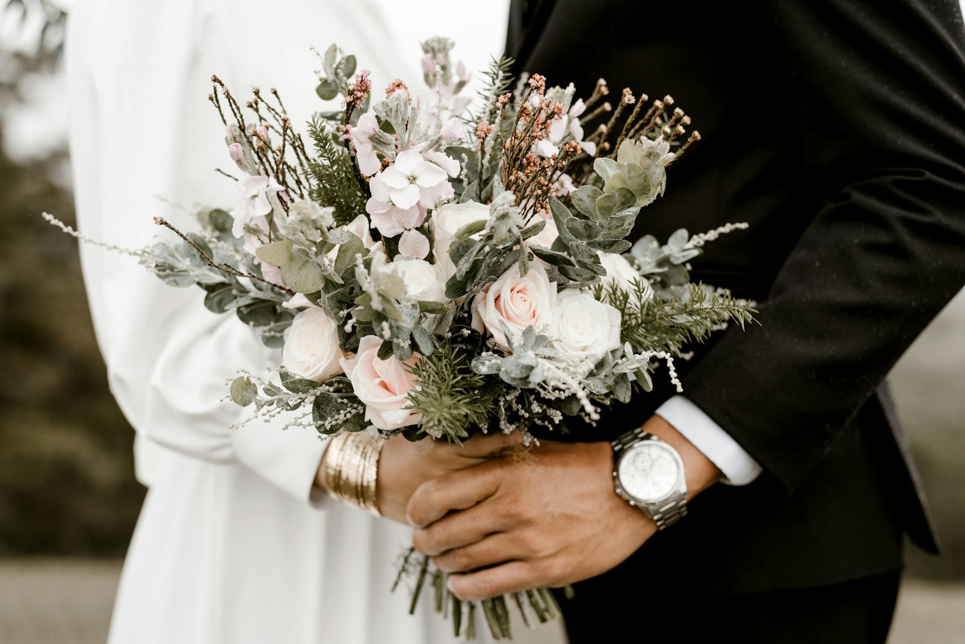 A bride and a groom holding a bouquet of flowers