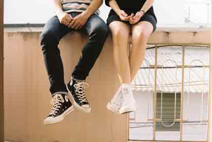 Couple sitting on a fence.